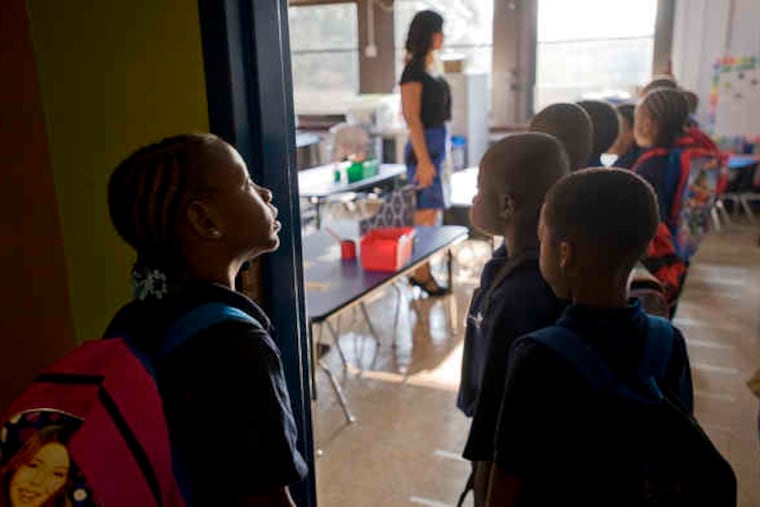 Iyanna Clark and her first-grade classmates wait to be checked in to Katie Harbaugh's class at Harrity, taken over by Mastery Charter Schools.