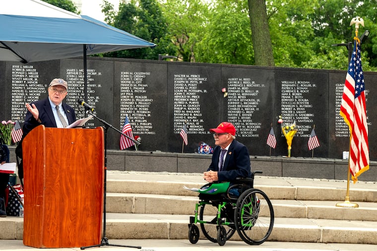 Former Daily News reporter Frank Dougherty delivers the keynote address as veterans and others gather at the Philadelphia Vietnam Veterans Memorial on Monday. At right is U.S. Marine Corps veteran Dennis Best, who led the grassroots efforts to build the permanent memorial at Penn’s Landing.