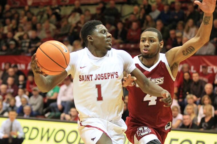 Shavar Newkirk, left, of St. Joseph’s drives to the basket against Unique McLean of Massachusetts during the 2nd half at Hagan Arena on Feb. 10, 2018.