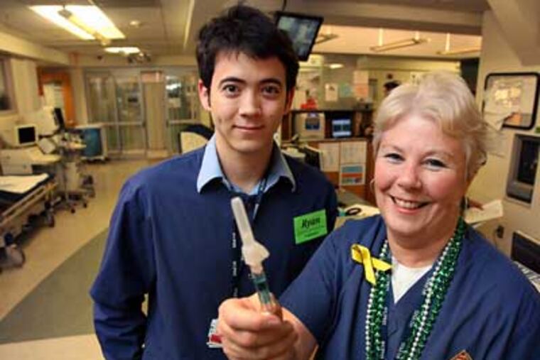 Ryan Leonard, left, and Mel Kearney at the Hospital of the University of Pennsylvania, with a flu vaccine. They have produced a YouTube video encouraging people to get a flu shot. (Laurence Kesterson / Staff Photographer)