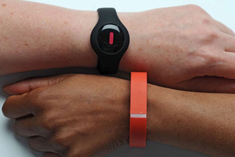 The trendy, yet fashionable accessory: fitness trackers, like the The Fitbug (top) and the Fitbit Flex. (Clem Murray/Staff Photographer)