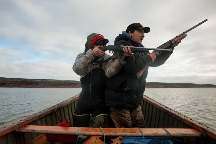 Daniel Inukpuk (left) and Jusipi Echalook taking aim while hunting for seal and eider ducks in Inukjuak, Quebec, in one of Monica Herndon's photos from October 2024.