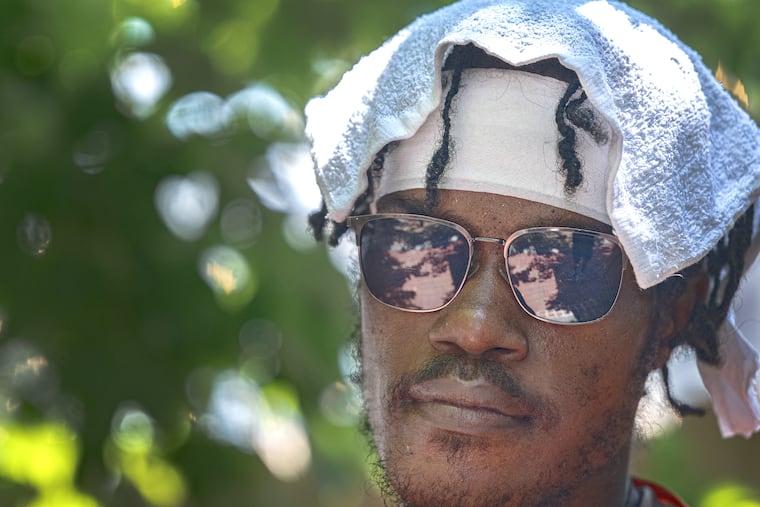 David Elder cools off with a cold towel draped over his head as he walks through South Philadelphia on Thursday, Aug. 6, 2026. Forecasters are predicting a heat wave across the region over the next several days.