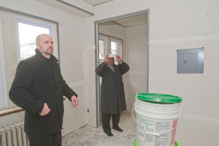 Oaklyn Mayor Bob Forbes (left) and Gino Lewis, director of housing for the Camden County Improvement Authority, look at an apartment being rehabilitated.