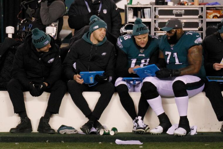 Eagles quarterback Josh McCown (18) on the sidelines with offensive tackle Jason Peters (71) and other teammates during the second quarter of Sunday's playoff loss to the Seahawks.