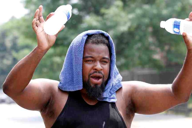 Alex Napper sells cold water to passersby in front of his house at Sixth and Jefferson Streets in North Philadelphia. He deep-freezes the water the night before. Around the city in the record heat, outreach workers dispensed water bottles and offered other assistance to the homeless.
