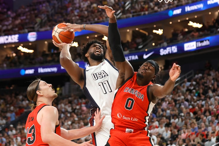 United States center Joel Embiid drives to the basket against Canada center Kelly Olynyk and point guard Lu Dort during the first half of an exhibition Wednesday in Las Vegas.