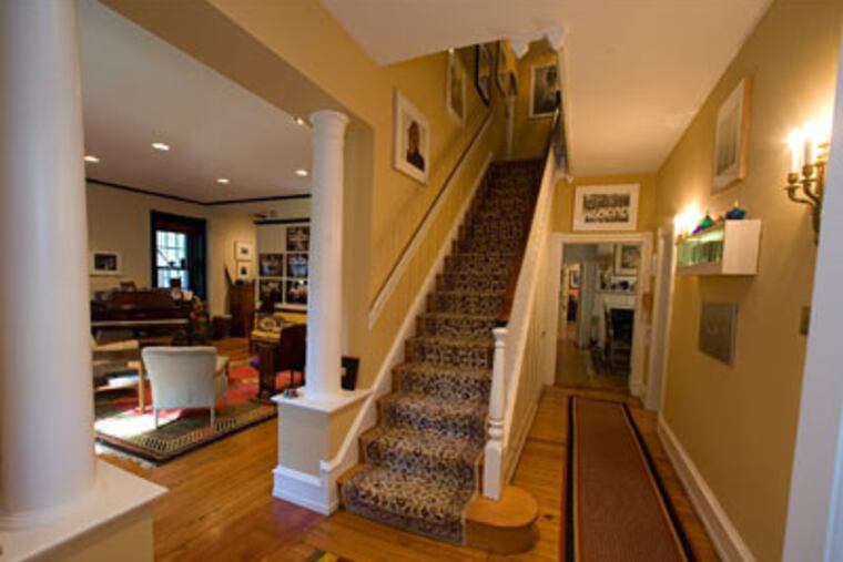 Elissa Topol is a crafts collector with an eclectic mix of antiques, commissioned furniture by woodworker artisans, ceramics, glass, jewelry and photography. In this photo, the first floor hallway with walls decorated in photographs and art leading to the living room, left, study right, and upstairs. (Ed Hille / Staff Photographer)