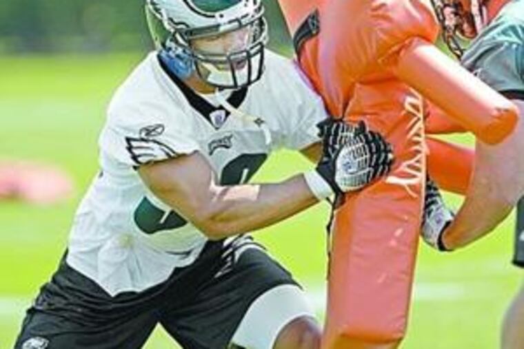 Fifth-round draft pick C.J. Gaddis (left) uses blocking pad at minicamp.
