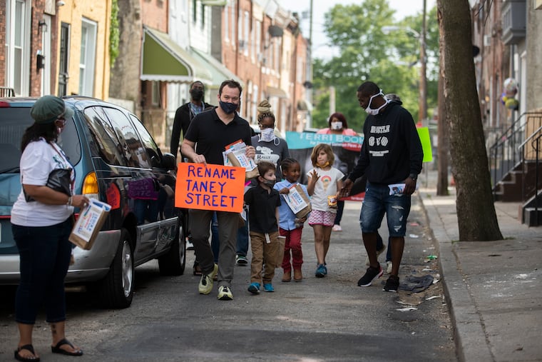 Participants distributed literature along Taney Street during a rally to rename Taney Street in May. Taney Street is named for Roger B. Taney, chief justice of the U.S. Supreme Court who wrote the Dred Scott decision.