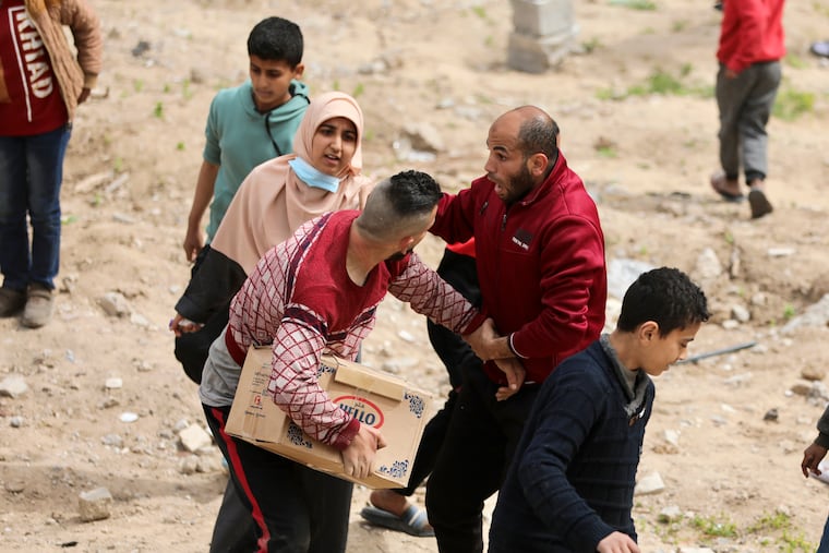 Palestinians rush to collect the humanitarian aid airdropped into Gaza City, Gaza Strip, on Sunday, March 17, 2024.