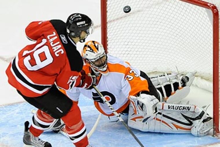 Travis Zajac watches his game-winning goal in the shootout as Brian Boucher falls to the ice. (Bill Kostroun/AP)