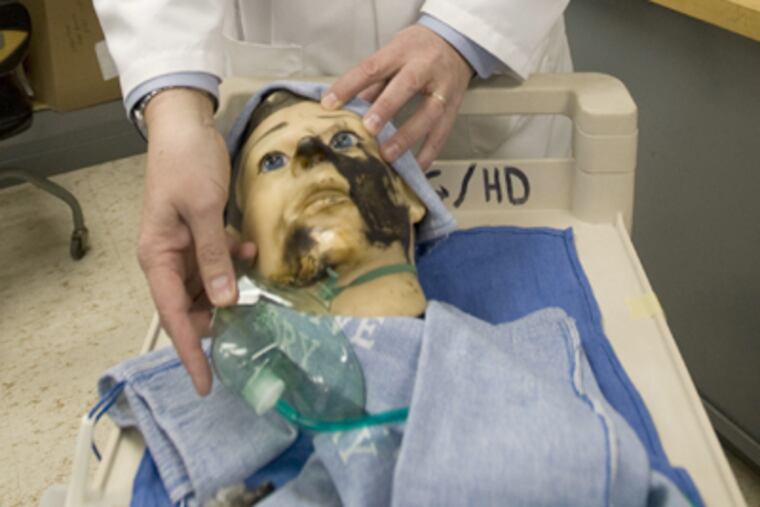Mark Bruley uses a mannequin in his lab to explain his findings in a surgical fire that burned a patient around the oxygen mask. (Clem Murray / Staff Photographer)