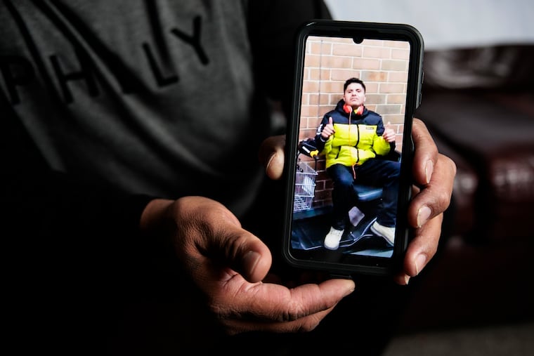 Lenin Suarez holds a photograph of his brother Victor, at his home on Dec. 10 in Seaford, Del.