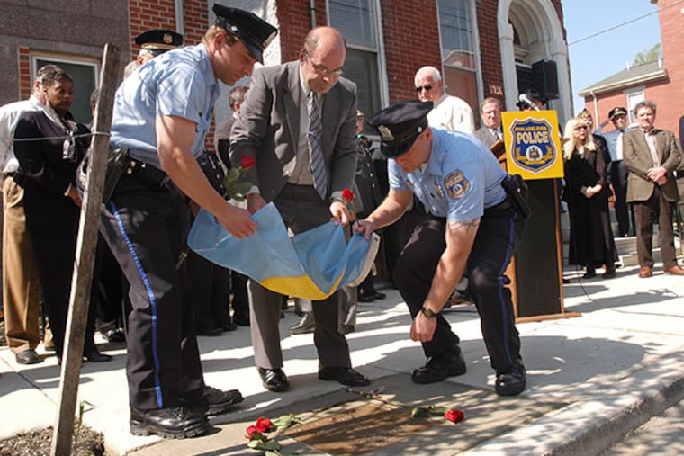 (From left to right) Vince Cione, Nick Cione, and Nick Cione, Jr., unveil a plaque commemorating their brother's death in 1970. (April Saul / Staff Photographer)
