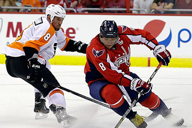 Capitals right wing Alex Ovechkin skates with the puck as he is defended by Flyers defenseman Nicklas Grossmann. (Alex Brandon/AP)
