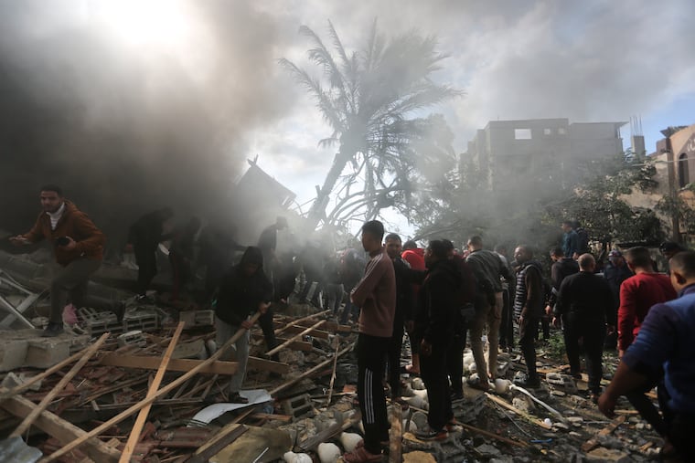 Palestinians look for the survivors of an Israeli strike in Rafah, Gaza Strip, on Thursday.