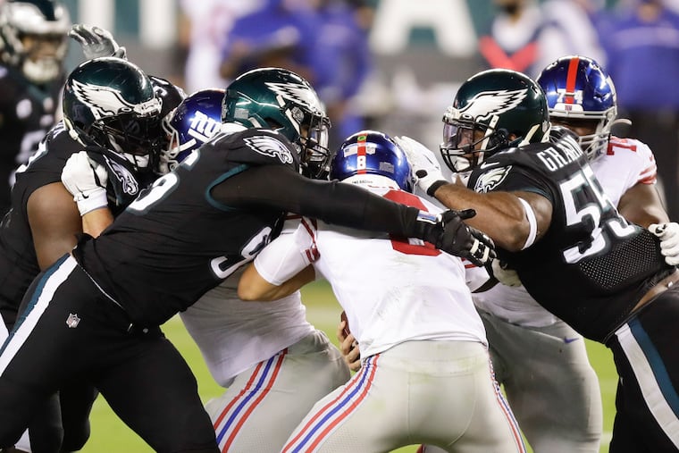 Eagles defensive ends Derek Barnett (left) and Brandon Graham (right) wrap up Giants quarterback Daniel Jones on Oct. 22.