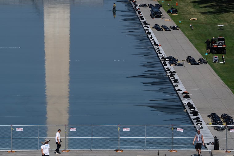 Workers install fireworks along the edge of the Lincoln Memorial Reflecting Pool ahead of the America 250 July 4th celebration on the National Mall, Thursday, July 2, 2026, in Washington.