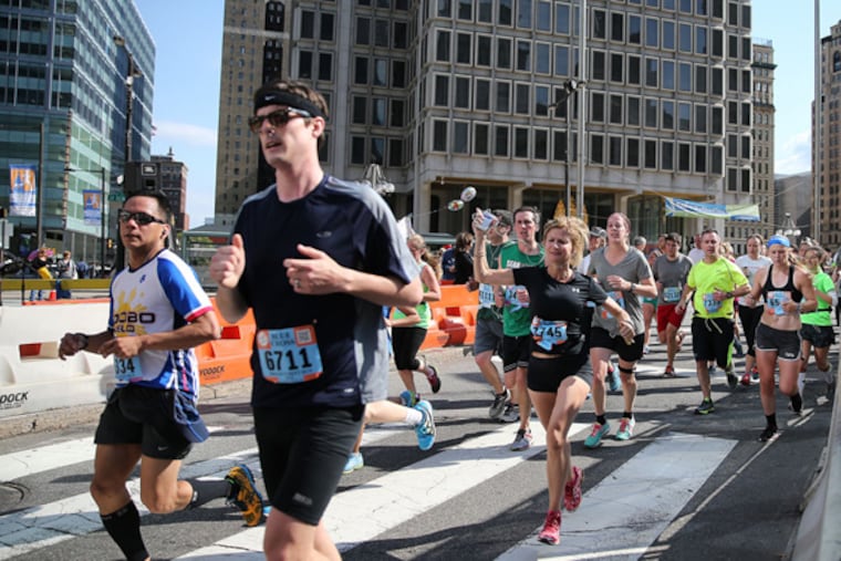 Runners make their way around City Hall during the Broad Street Run in Philadelphia on May 4, 2014. ( DAVID MAIALETTI / Staff Photographer )