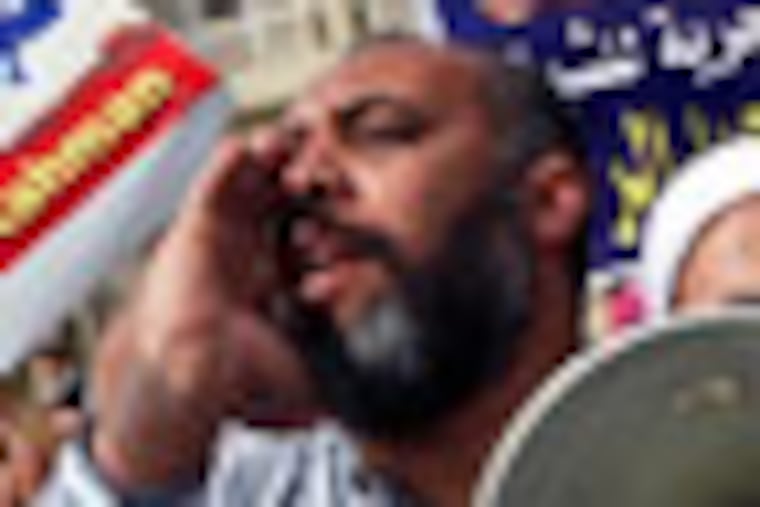 Egyptian protesters hold posters showing Sheikh Omar Abdel-Rahman, who is imprisoned in the US, and call for his release outside a court in Cairo, Egypt, Sunday, Feb. 26, 2012. Egypt went forward with a trial Sunday that has plunged relations with the U.S. into the deepest crisis in decades, prosecuting 16 Americans and 27 other employees of pro-democracy groups on charges they used foreign funds to foment unrest. The Arabic writing on the banners reads: "Freedom for Sheikh Omar Abdel Rahman". (AP Photo/Khalil Hamra)