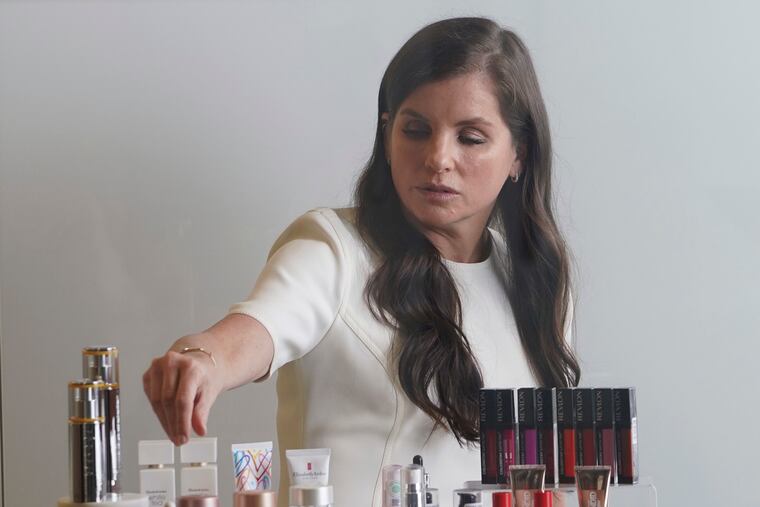 Revlon CEO Debra Perelman shows products during an interview in 2021.