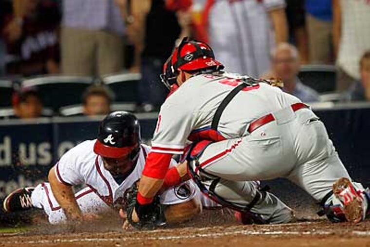 Carlos Ruiz tags out Dan Uggla at home on a throw by Hunter Pence in the sixth inning. (John Bazemore/AP)