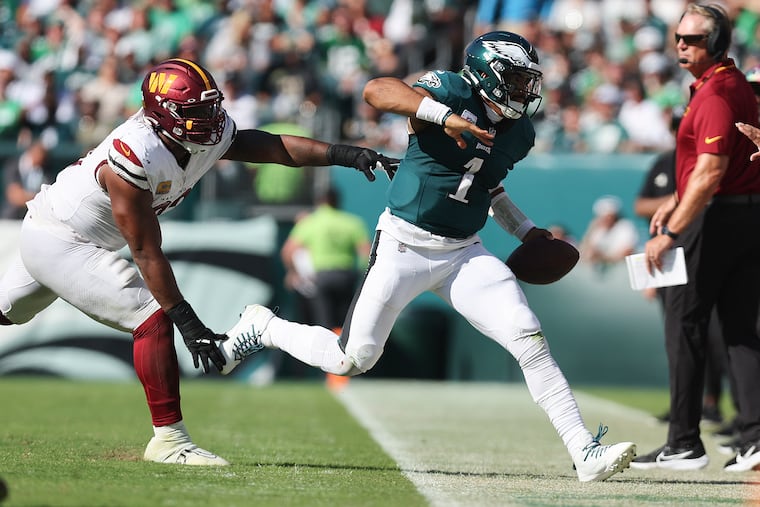 Eagles quarterback Jalen Hurts gets shoved out of bounds by Commanders defensive tackle Jonathan Allen during the third quarter Sunday.