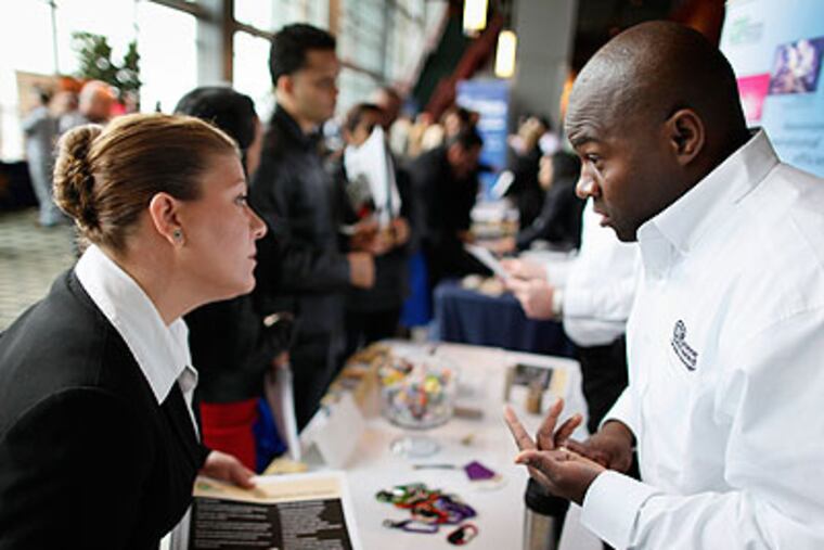 Laura White (left), 37, of Philadelphia, talks to Muneer El-Amin, a corporate recruiter. White is retiring as a Marine and is looking for a job. (Michael S. Wirtz / Staff Photographer)