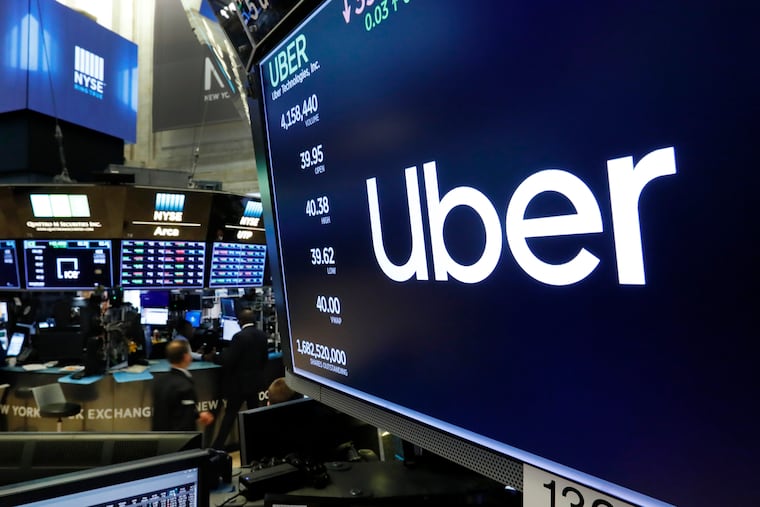 The logo for Uber appears above a trading post on the floor of the New York Stock Exchange.