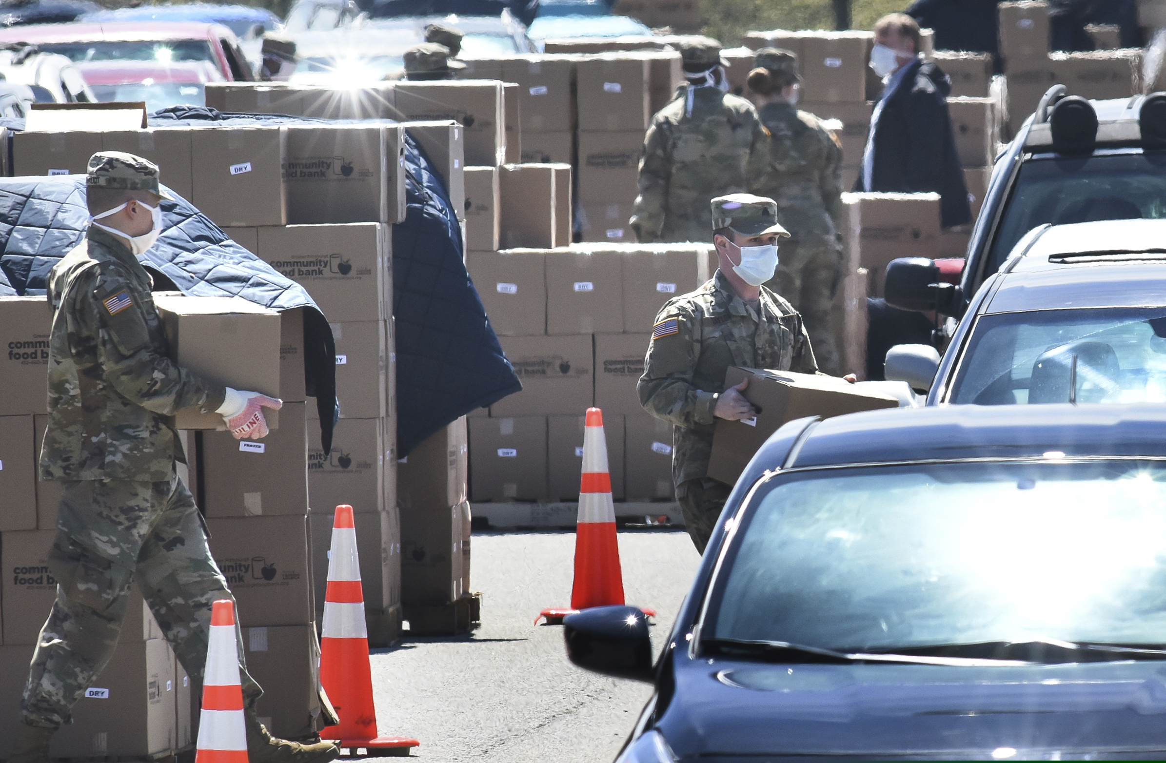 Members of the 128th Brigade Support Battalion of the Pennsylvania Army National Guard work loading boxes of food into cars at a distribution for the Greater Pittsburgh Community Food Bank, Monday, April 20, 2020, in Duquesne, Pa. The food bank has seen a sharp increase in need since statewide shutdowns of nonessential businesses in the COVID-19 pandemic. (Darrell Sapp/Pittsburgh Post-Gazette via AP)