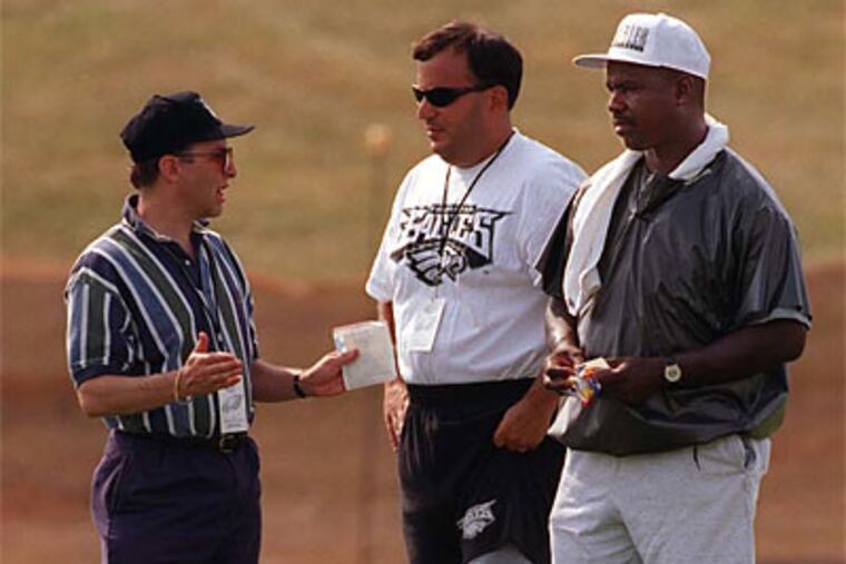 Ray Rhodes (right) and Mike Lombardi (center) talk withJoe Banner at training camp in 1997. (Jerry Lodriguss/Staff file photo)