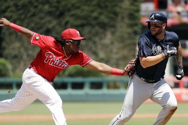 Philadelphia Phillies third baseman Maikel Franco, left, tags out Atlanta Braves' Matt Adams after Adams tried to score on a fielder's choice by Danny Santana during the second inning of a baseball game, Monday, July 31, 2017, in Philadelphia. (AP Photo/Matt Slocum)