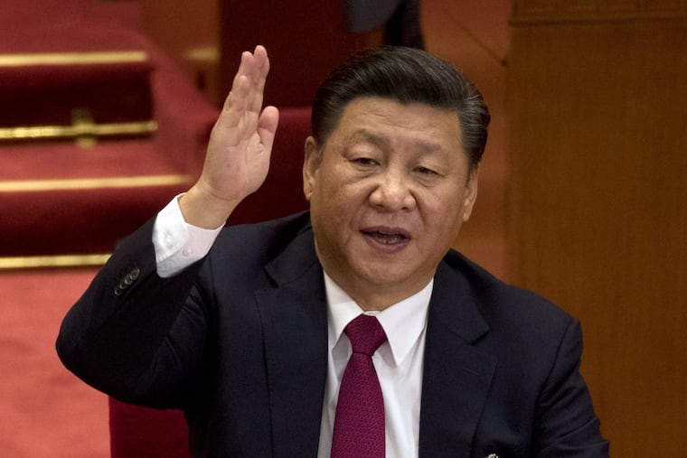 Chinese President Xi Jinping raises his hand to show approval of a work report during the closing ceremony for the 19th Party Congress held at the Great Hall of the People in Beijing on Tuesday.