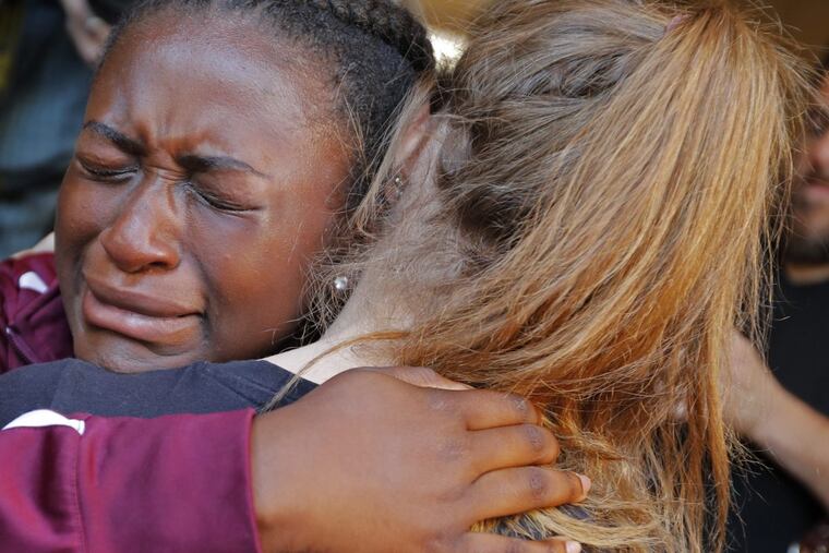 Marla Eveillard, 14, cries as she hugs friends before the start of a vigil at the Parkland Baptist Church, for the victims of Wednesday's shooting at the Marjory Stoneman Douglas High School in Parkland, Fla., Thursday, Feb. 15, 2018. Nikolas Cruz, a former student, was charged with 17 counts of premeditated murder Thursday morning. (AP Photo/Gerald Herbert)