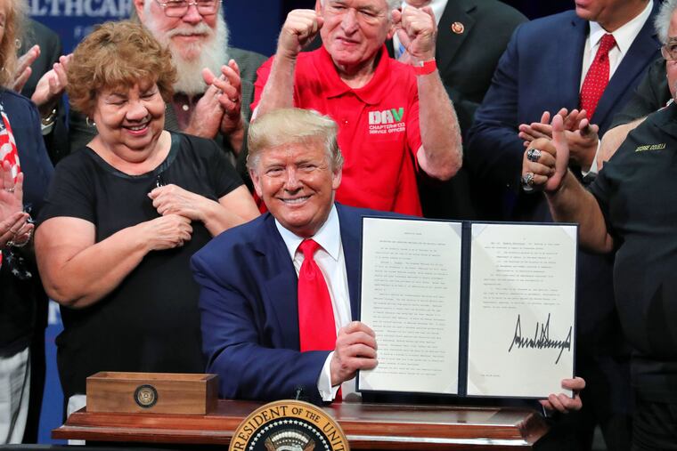 President Donald Trump shows the executive order on Medicare he signed during his appearance at the Sharon L. Morris Performing Arts Center in The Villages, Fla., on Oct. 3.