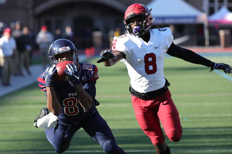 Penn's Mike Akai catches a pass as Harvard's Bennett Bay defends at Franklin Field in Philadelphia..