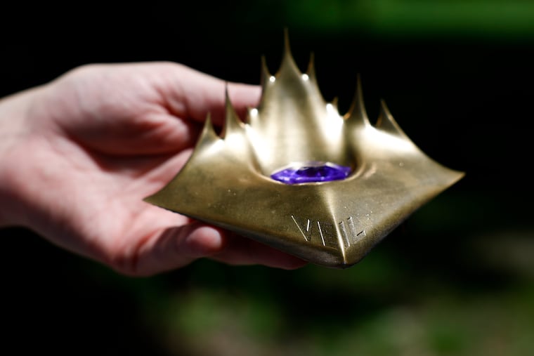 Jeff DuVilla holds the “Veil” treasure while in West Fairmount Park on Monday, May 12, 2025, in Philadelphia. He and his brother Paul started a treasure hunt game called Veil.