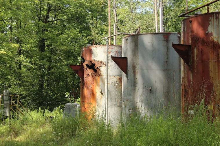 A conventional oil and gas tank battery stands in disrepair in the Allegheny National Forest of northwest Pennsylvania in 2023.