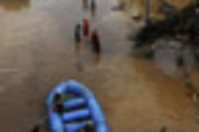 Rescuers paddle their rubber boat to search for survivors following a flash flood that inundated Cagayan de Oro city, Philippines, Saturday, Dec. 17, 2011. A tropical storm triggered flash floods in the southern Philippines, killing scores of people and missing more. Mayor Lawrence Cruz of nearby Iligan said the coast guard and other rescuers were scouring the waters off his coastal city for survivors or bodies that may have been swept to the sea by a swollen river. (AP Photo/Froilan Gallardo)