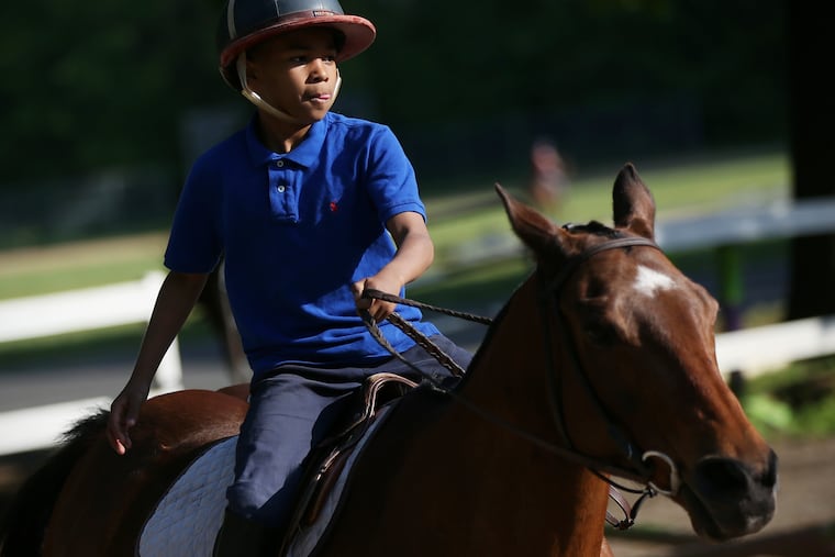 Schyler Smith, 8, of South Philadelphia, rides a polo pony in the arena at the Chamounix Equestrian Center in Philadelphia's West Fairmount Park on Tuesday, May 7.