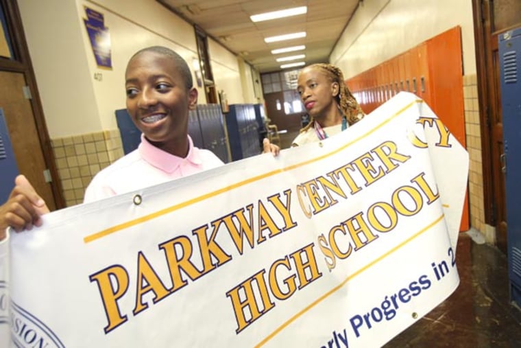 Tauheed Baukman, left, couldn't imagine what his high school will be like under the Philadelphia's School District's doomsday budget. So the senior at Parkway Center City High School took matters into his own hands. He created a petition and posted it at Change.org to draw attention to the schools' plight and put pressure on politicians to step up and help a foundering system. He's getting signatures from near and far. He's also volunteering with friends at his high school this summer calling freshmen to attend orientation, putting up posters and helping the principal prepare for the opening of school Sept. 9. "I pretty much help out any way I can," Baukman said. Tauheed and Principal Karren (CQ) Dunkley talk about where a banner should be hung on Aug. 6, 2013. They can't hang it till painting is done. ( CHARLES FOX / Staff Photographer )