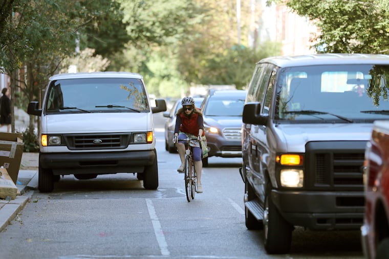 A bicyclist weaves into traffic to avoid a parked van in the bike lane on Pine Street.