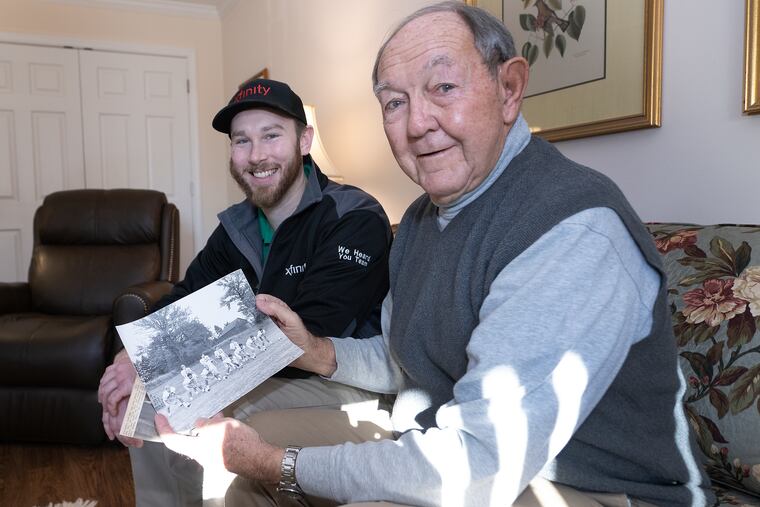 Tyler Vanderslice (left) and former Upper Dublin High School football coach John Pavlick look at old photographs of Vanderslice's father, Jack.