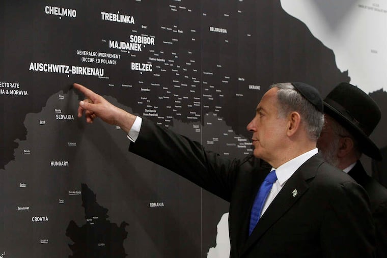 Israeli Prime Minister Benjamin Netanyahu points at a map of death sites during the opening of a new pavilion at the former Auschwitz camp.