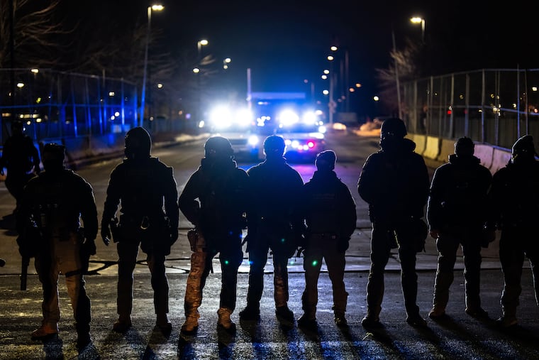 Federal officers stand guard after detaining people outside of Bishop Henry Whipple Federal Building, Jan. 13, 2026, in Minneapolis.