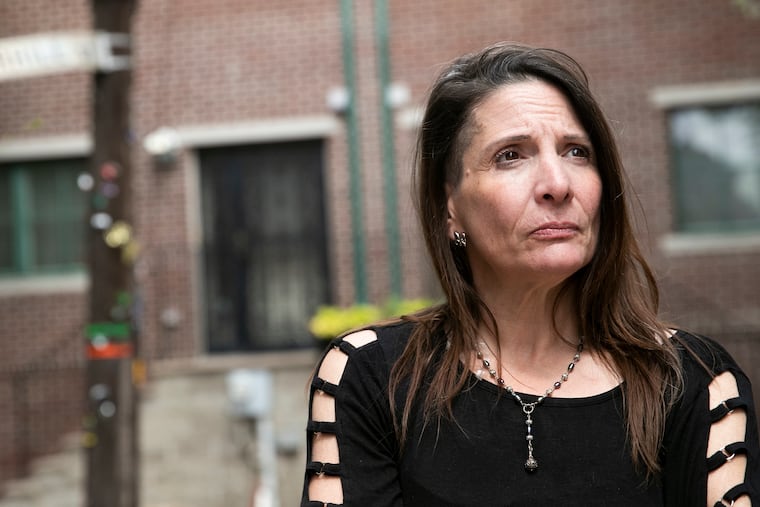 Natalie Pompilio poses for a portrait outside of her Bella Vista home in Philadelphia. Pompilio is mourning her father, who died from COVID-19 last May after being hospitalized a year ago this month.