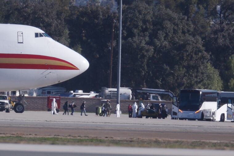 Passengers board buses after arriving on an airplane carrying U.S. citizens being evacuated from Wuhan, China, at March Air Reserve Base in Riverside, Calif. Jan. 29, 2020.