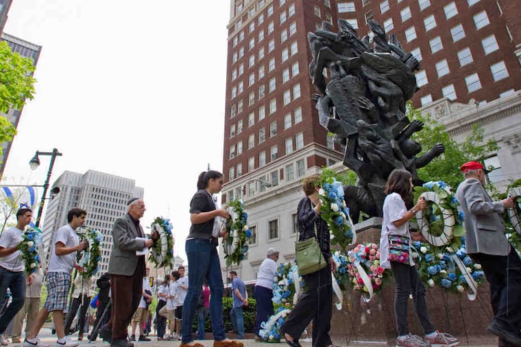At the foot of "Monument to Six Million Jewish Martyrs" on the Parkway at 16th Street, participants bear wreaths in memory of those who died in the Holocaust