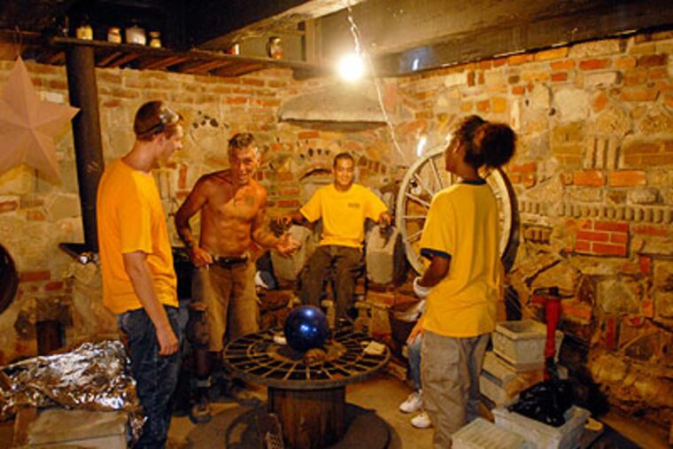 Jeffrey Tirante (second from left) tells New Jersey Youth Corp volunteers about the underground story telling room of "The Palace of Depression" he is rebuilding in Vineland. (Ron Tarver / Staff Photographer)